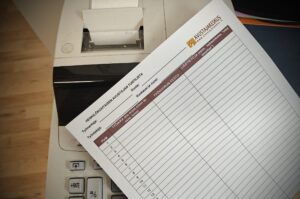 Kuvassa tuntilista ja vanha laskin